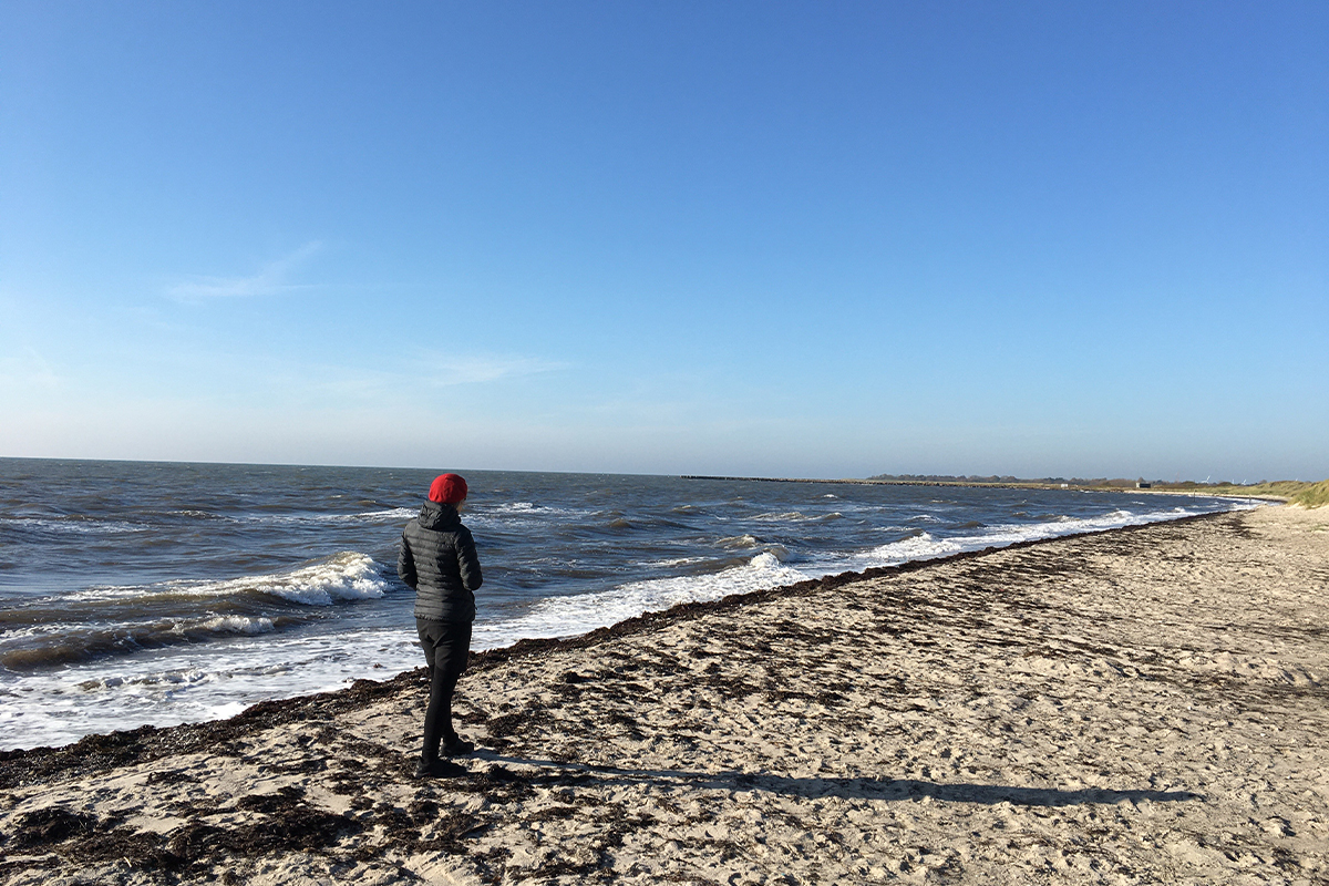 Kvinde i vandkanten nyder udsigten over Kramnitze Strand
